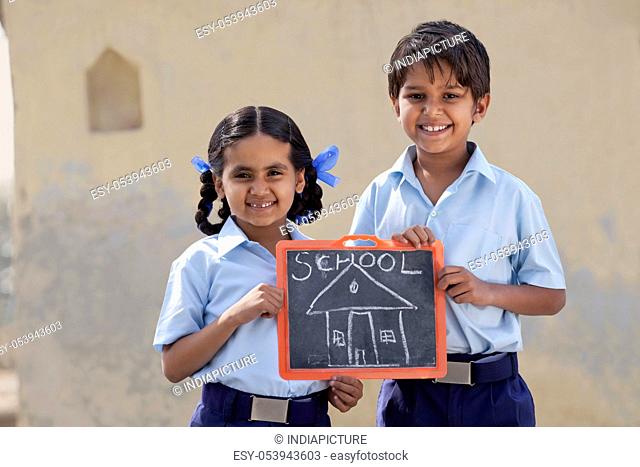 Portrait of happy children holding a slate