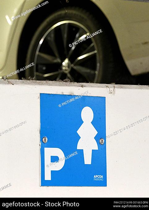 14 December 2023, Brandenburg, Potsdam: A sign with the logo for ""women's parking"" is displayed in front of a parking bay in the parking garage at the main...