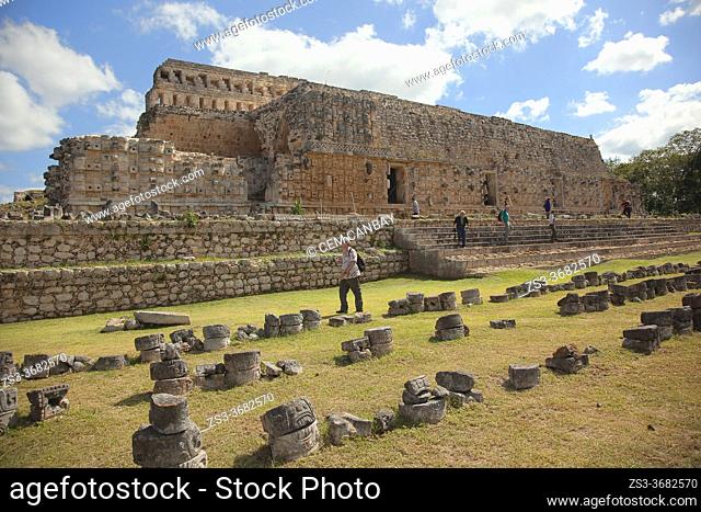 Visitors in front of the Palace Of Masks-El Palacio De Los Mascarones or Codz Poop in Maya Archaeological Site Kabah in the Puuc Route, Yucatan State, Mexico