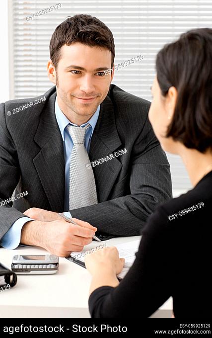 Happy young adviser businessman consulting at office, smiling