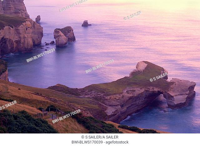 Seascape, view down to the rugged coastline of Tunnel Beach with sea stacks and rock arches, at dawn right before sunrise, New Zealand, Southern Island, Otage
