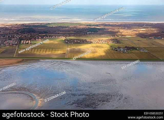 Aerial view Dutch island Schiermonnikoog while the sunlight is shining at the fields