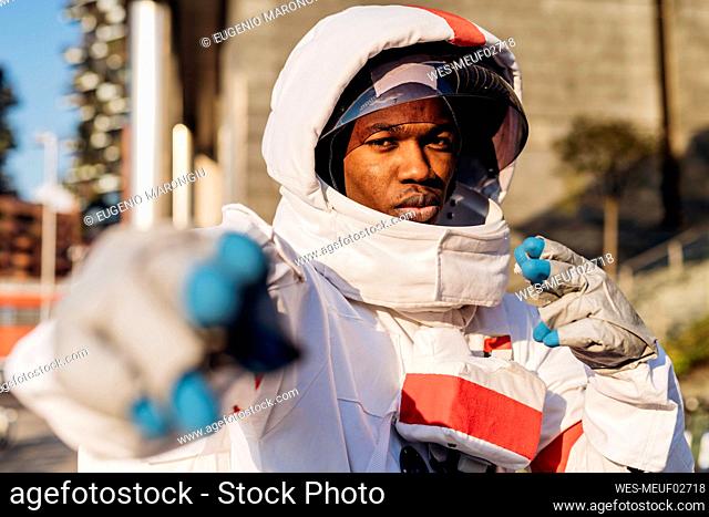 Male astronaut wearing space helmet gesturing