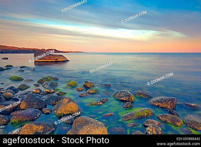 Sunset over the rolling stones of the Norwegian coast, Moelen