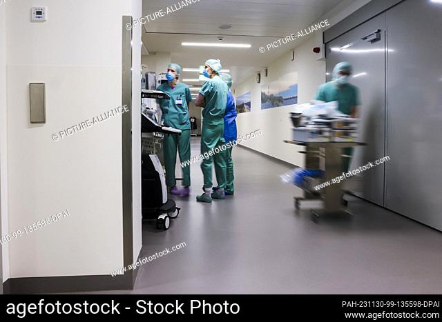 PRODUCTION - 29 November 2023, Schleswig-Holstein, Rendsburg: Nursing staff and doctors talk in a corridor in the Schön Klinik operating center