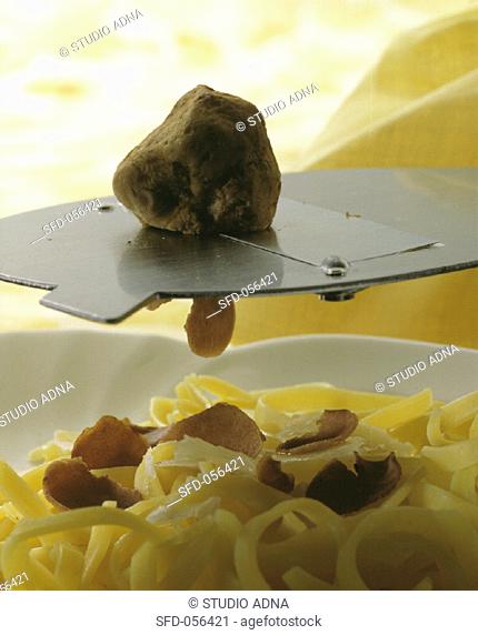 Shaving truffle over pasta