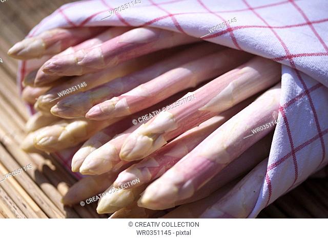 fresh white aspargus enveloped in a tea towel