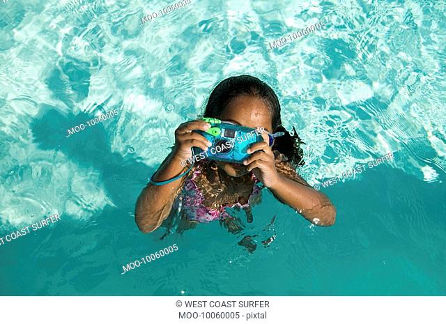 Girl 5-6 Using Waterproof Camera in Swimming Pool overhead view