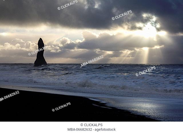 Sunrays filter through the clouds at the beach of Reynisfjara, Vik, Sudurland, Iceland, Europe