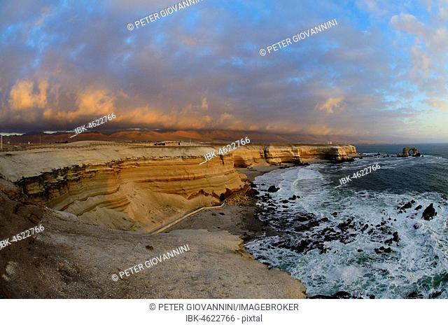 Rocky coast with arch La Portada at sunset with clouds, Antofagasta, Región de Antofagasta, Chile