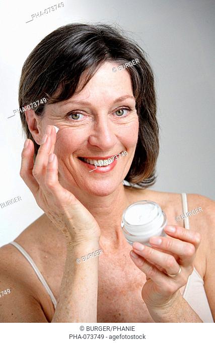 Woman applying moisterizing cream