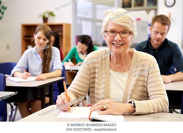 Happy senior woman at an adult education class looking to camera