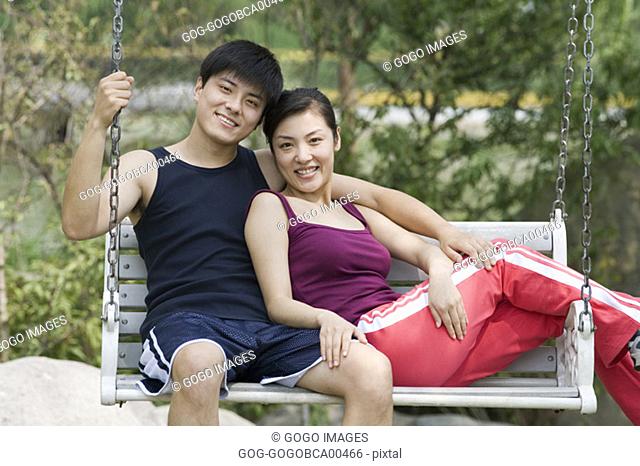 Young couple sitting on a swing together