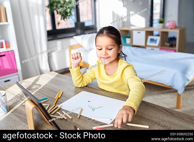 little girl drawing with coloring pencils at home