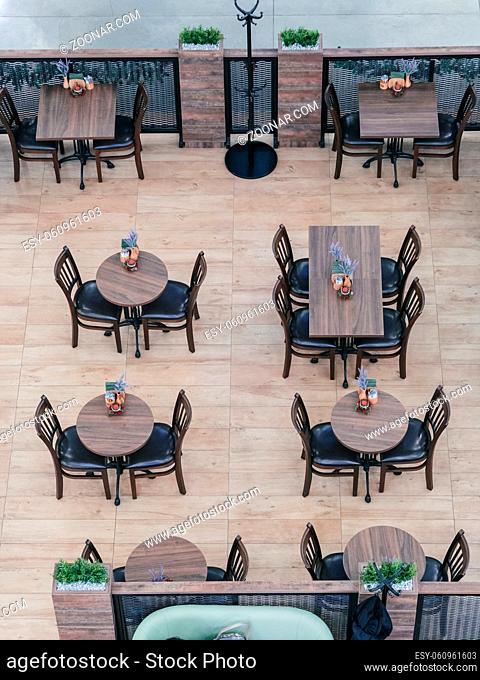 Above view of cafe with empty tables and chairs in shopping mall. Top view cafe indoors
