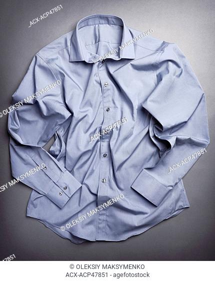 Photo of artistically crumpled mens dress shirt on gray background