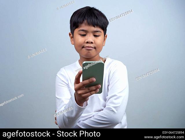 Social media and technology concepts. Boy's hands holding a smartphone and stylus pencil to use multimedia and social media to communicate