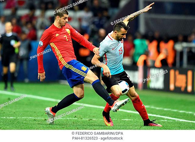 Alvaro Morata (L) of Spain vies for the ball with Mehmet Topal (R) of Turkey during the Group D soccer match of the UEFA EURO 2016 between Spain and Turkey at...
