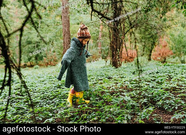 Girl wearing oversized sweater and walking in forest