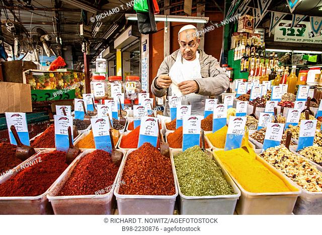 A vendor sells a large selection of Fresh ground spices in Tel Aviv's Carmel Market
