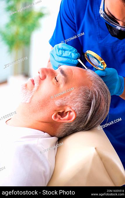 Old man visiting young male doctor in hair transplantation concept