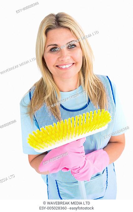 Cleaner woman holding a yellow broom in the white background
