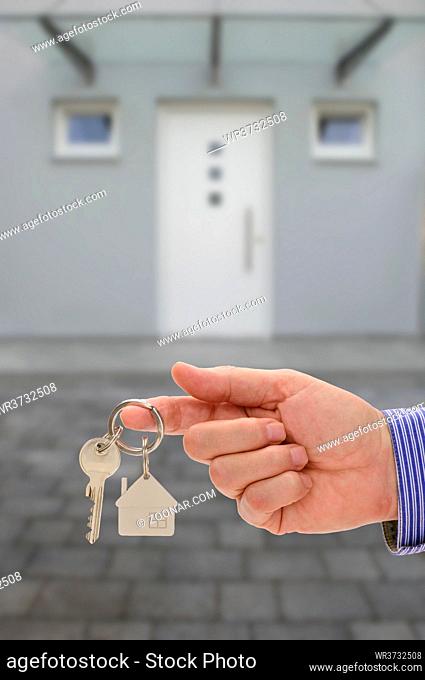 house key on ring in hand of real estate agent