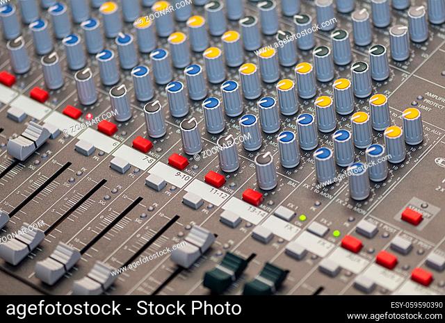 Close-up on knobs of an audio console. Digital audio board. Studio workstation. Mixing console
