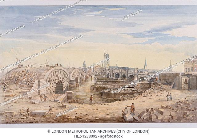 View of London Bridge on the right and the construction of the new bridge on the left. Also with workmen, including two moving a stone slab in foreground and...