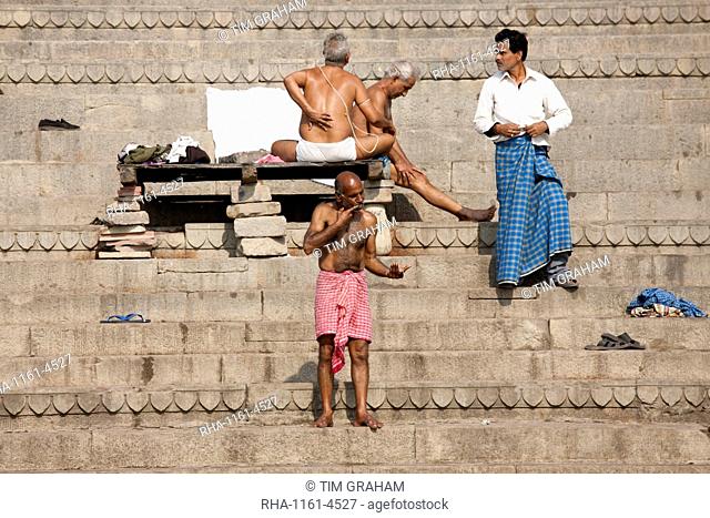 Men bathing at Dharbanga Ghat by the Ganges River in City of Varanasi, Benares, Northern India