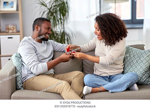 african american man giving woman engagement ring