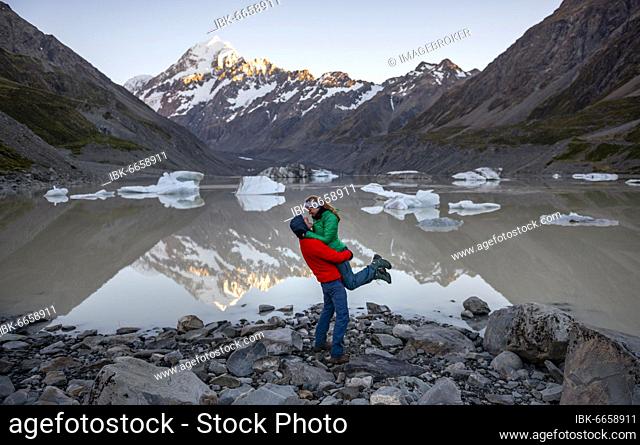 Young couple at Hooker Lake, Mount Cook in morning light, reflection in lake, sunrise, Mount Cook National Park, Southern Alps, Hooker Valley, Canterbury