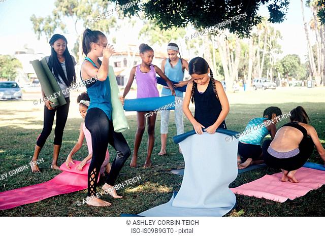 Schoolgirls preparing for yoga practice on school sports field