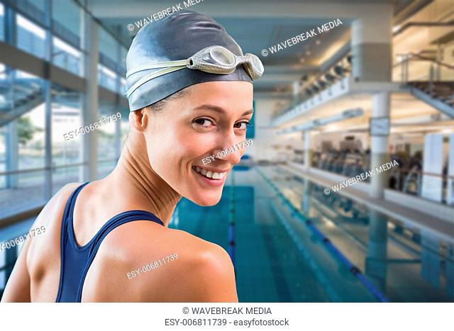 Composite image of pretty swimmer by the pool smiling at camera