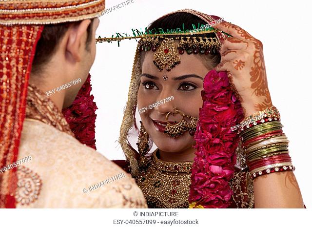 Gujarati bride putting a garland on a groom