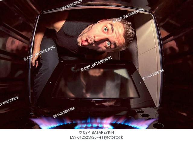 man and lit oven
