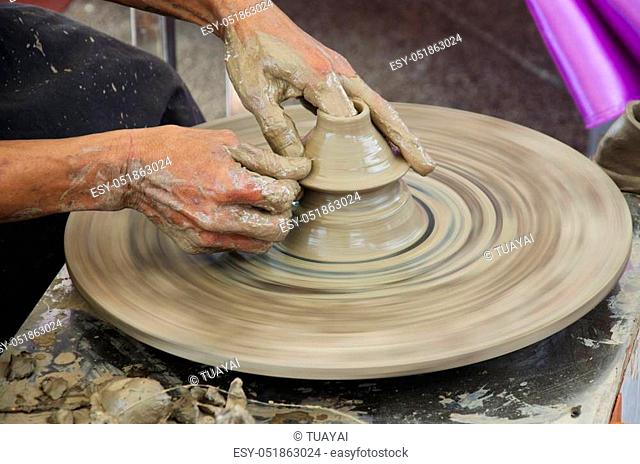 Professional thai old man using mechanic pottery made earthenware for show in traditional culture thai festival at Koh Kret Island in Nonthaburi Thailand