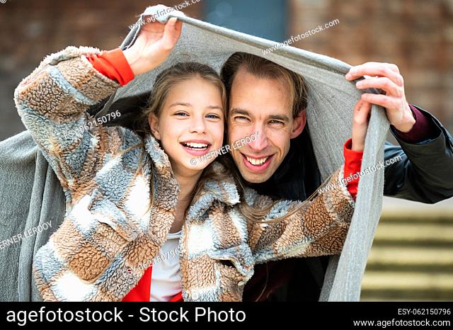 12 yo blonde daugther having fun with her 42 yo father, covered under a blanket, Brussels, Belgium