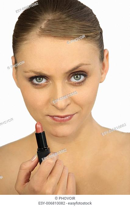 Woman putting on lipstick