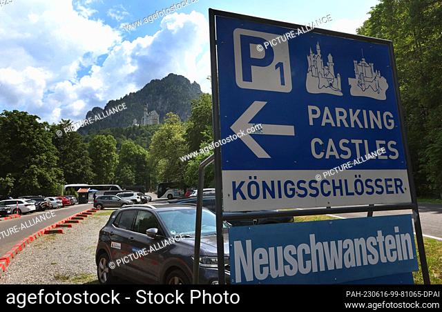 16 June 2023, Bavaria, Schwangau: Cars are parked in a parking lot below Neuschwanstein Castle. A man pushed two female tourists into a ravine near...