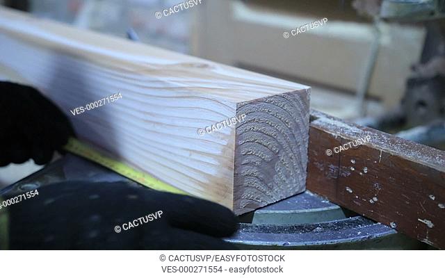 Circular saw cutting wooden plank in workshop