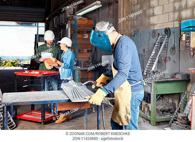 Metallarbeiter beim Schweißen von Stahl in Schutzkleidung in einer Metall Werkstatt