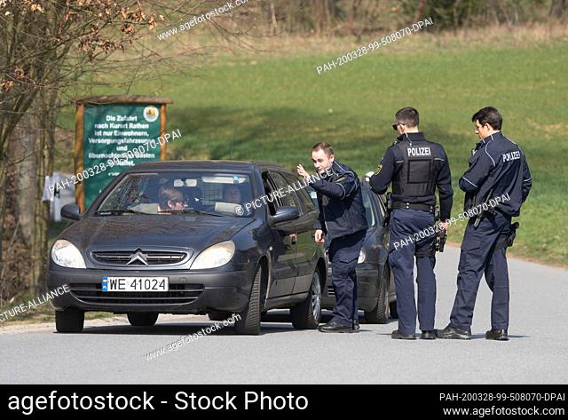 28 March 2020, Saxony, Rathen: Police officers are checking a car driver near Rathen in the Saxon Switzerland. The District Office Saxon Switzerland-Eastern Ore...