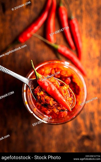 Red hot chili paste and chili pepper on spoon. Top view