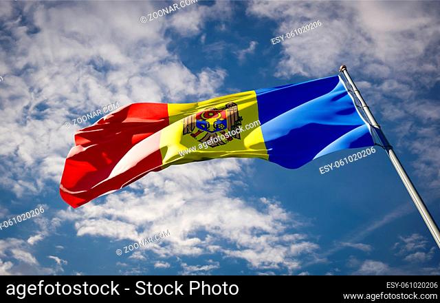 Beautiful national state flag of Moldova fluttering at sky background. Low angle close-up Moldova flag 3D artwork