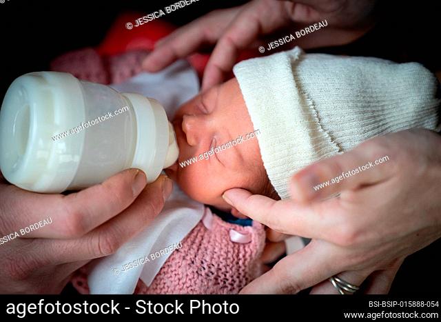 Parents bottle-feed the newborn who has just woken up