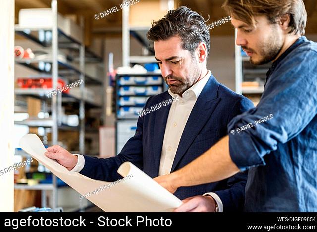 Businessman and employee discussing plan in factory