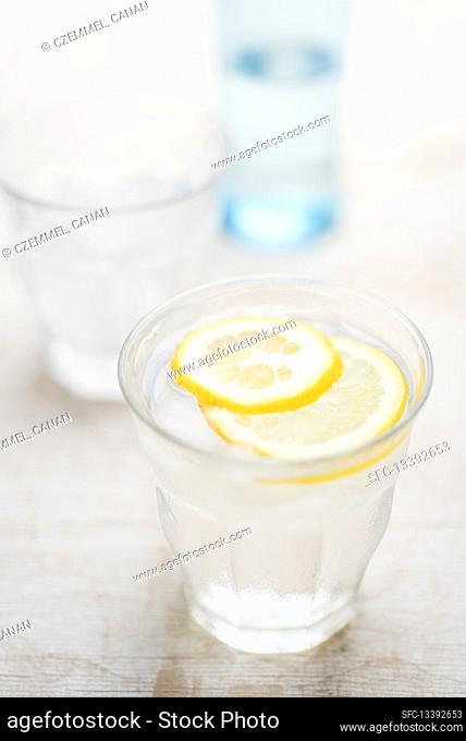 Fresh water in a glass with ice cubes and lemon slices
