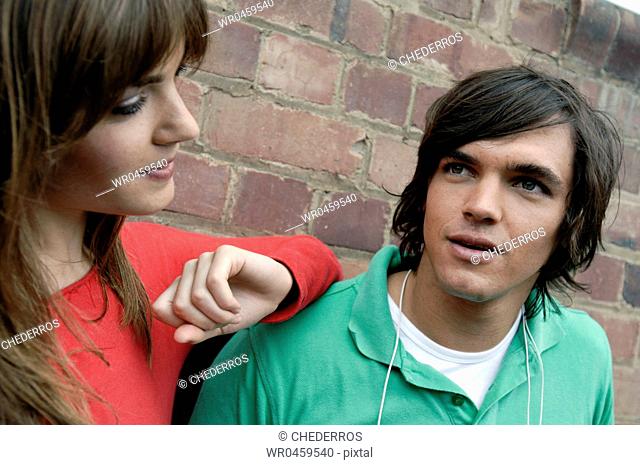Close-up of a young couple in front of a brick wall