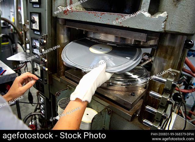 20 August 2020, Lower Saxony, Diepholz: A record is taken from the press. Not only nostalgics rely on vinyl. LPs and singles are a must for many musicians and...